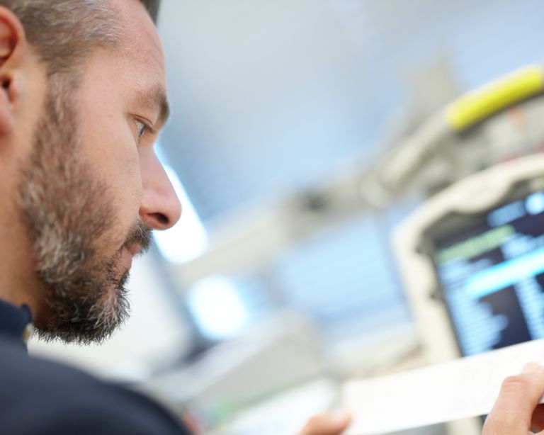 Image of a healthcare professional using a medical device that requires paper.