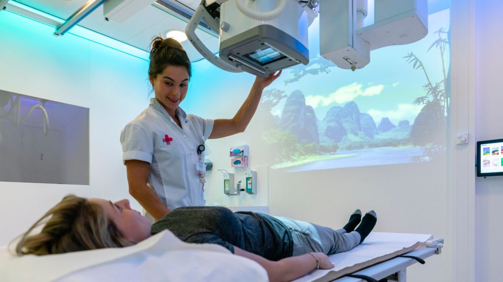 Technician completing patient set up for abdominal X-ray