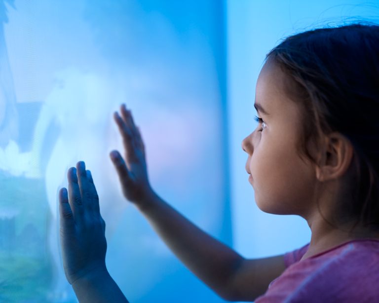 Pediatric patient is looking to the ambient experience wall in the MR room