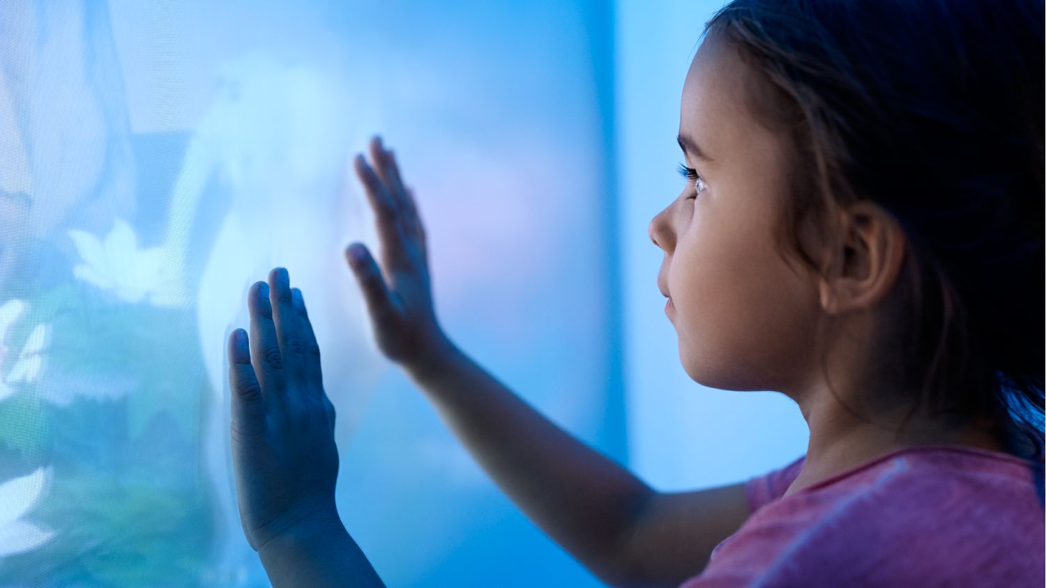 Pediatric patient is looking to the ambient experience wall in the MR room