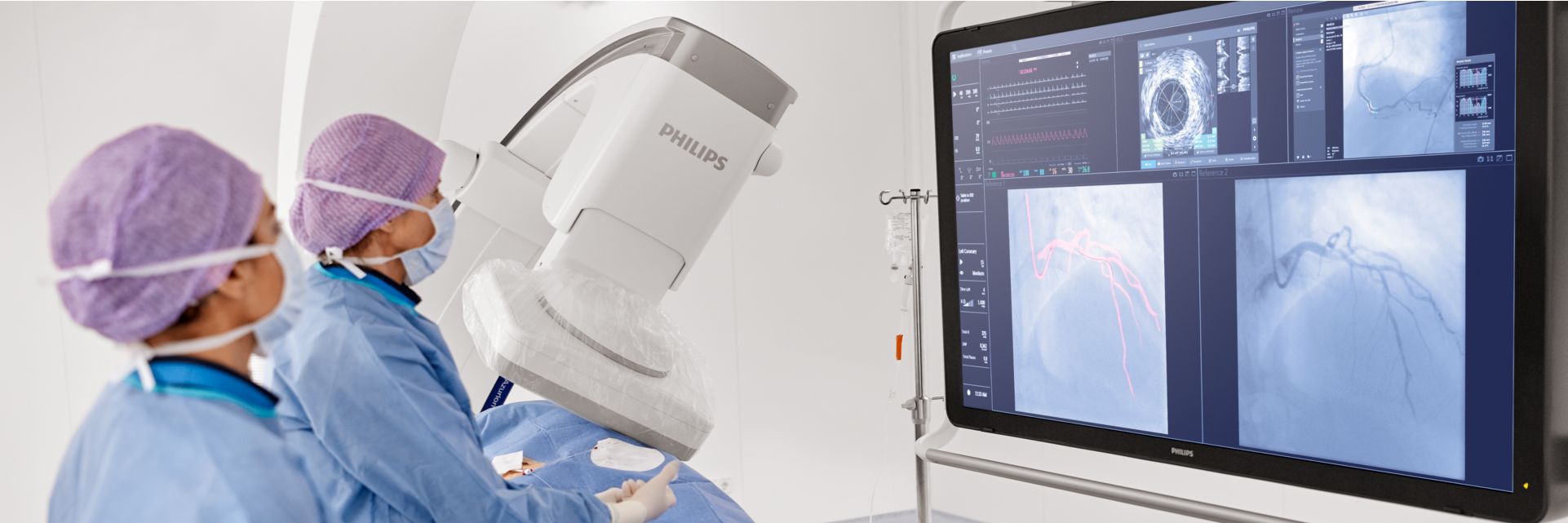 Two clinicians viewing screens using ClarityIQ during interventional procedure.