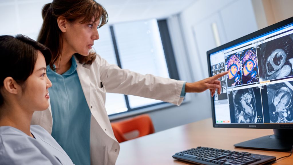 Radiologists look at a cardiac exam on a monitor.