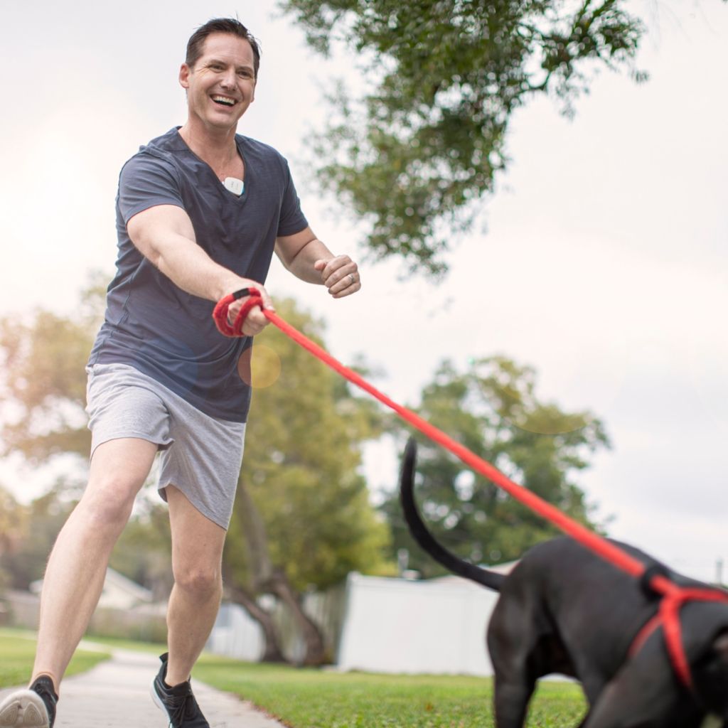 A man wears Philips Extended Holter – ePatch while walking his dog.