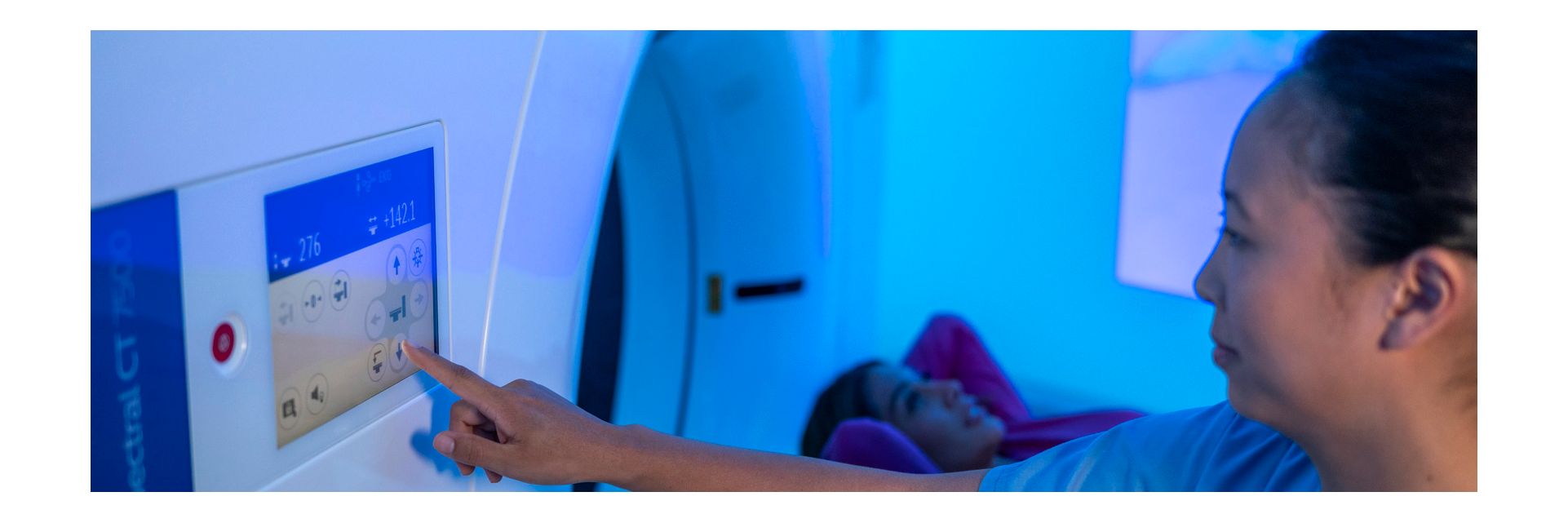 CT technologist using control panel