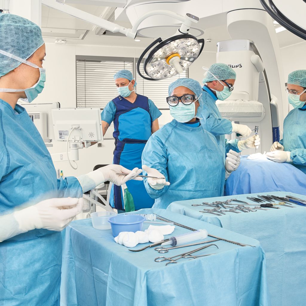 Clinicians perform an interventional procedure in the hybrid OR using Azurion FlexArm with Getinge OR table.
