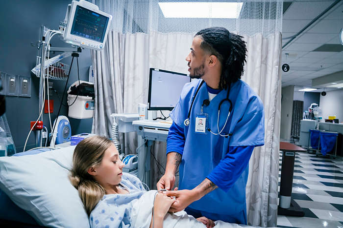 A care provider checks on a young patient