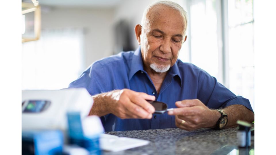 A man takes a blood glucose reading at home