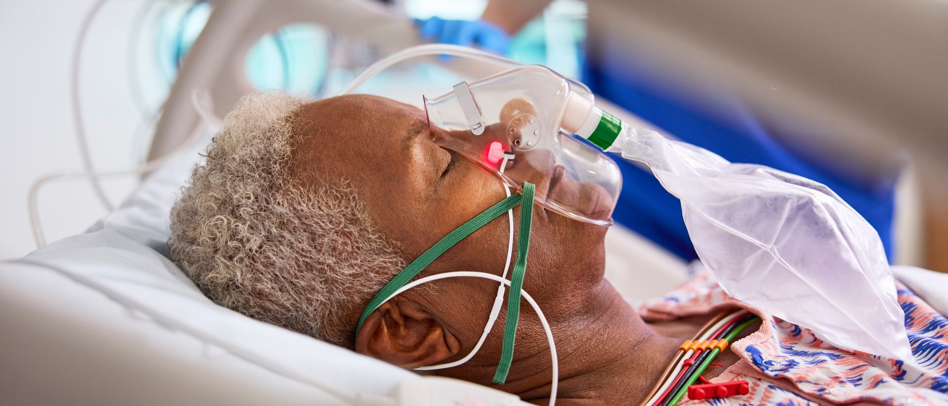 Woman lying in hospital bed with Alar sensor and oxygen mask
