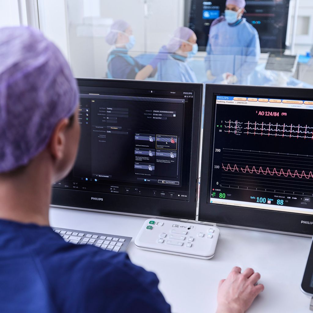 A clinician accesses information while physicians care for a patient