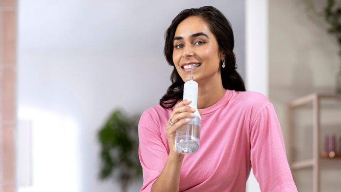 Woman using the Philips Sonicare Power Flosser