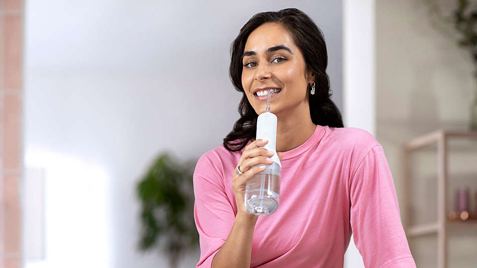 Woman using the Philips Sonicare Power Flosser