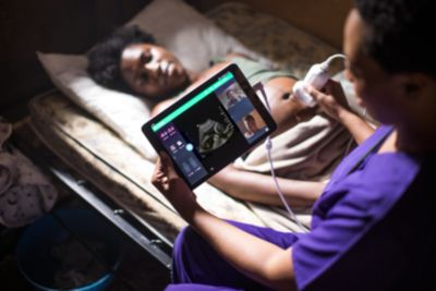 A midwife performing an ultrasound scan on a pregnant woman