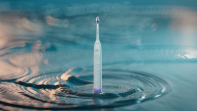Philips Sonicare electric toothbrush standing upright in water ripple