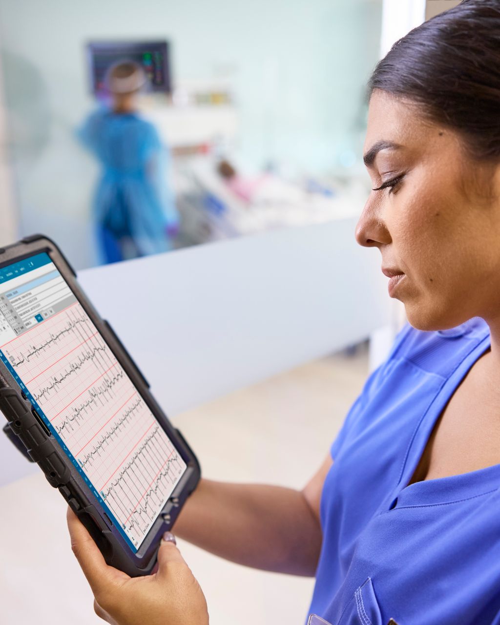 A clinician reviews ECG data on a tablet device while on the go.