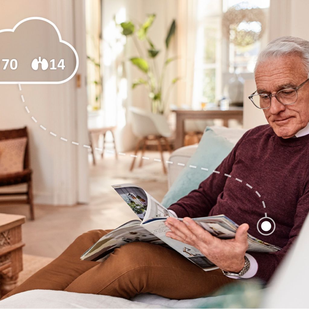 man reading magazine whilst monitored by biosensor