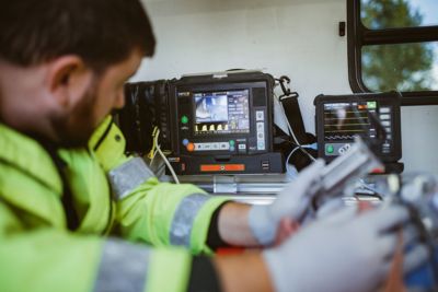 Secouriste utilisant un équipement de surveillance portable à l'intérieur d'une ambulance