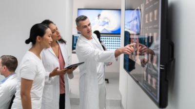 Medical team reviewing diagnostic images on large display in clinical setting