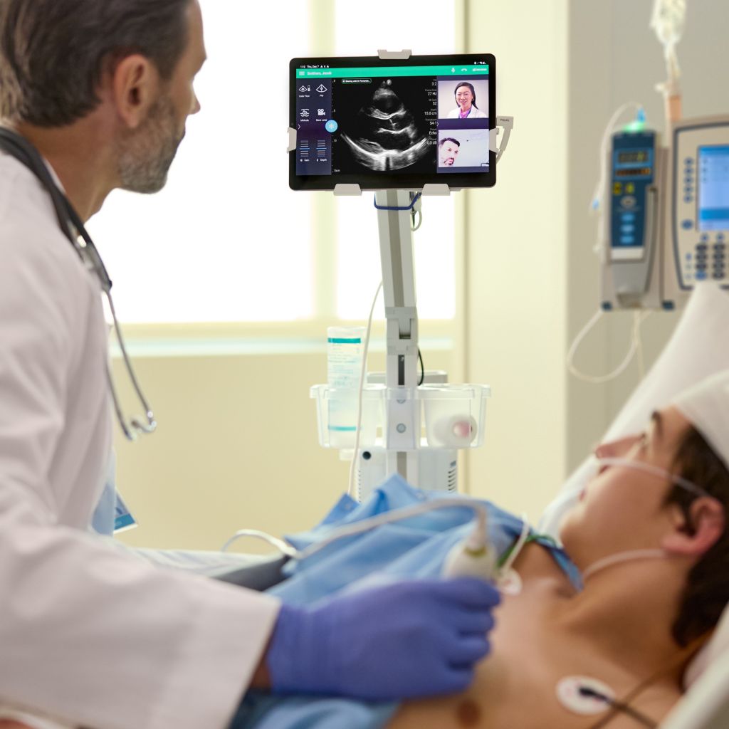 Critical care clinician performing mobile ultrasound with tele-ultrasound on young patient. 

 