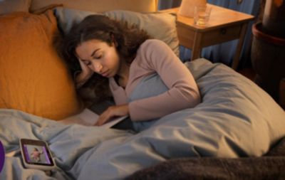 Die Mutter ruht im Bett mit einem Babyphone in der Nähe
