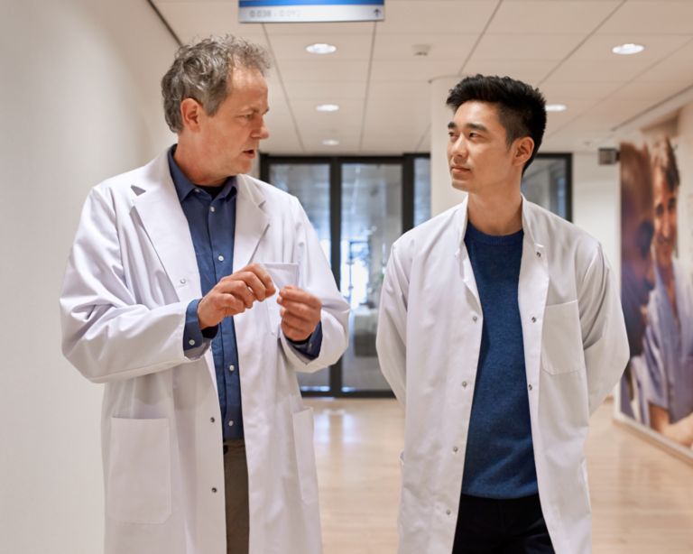 Two male doctors talking in hospital corridor