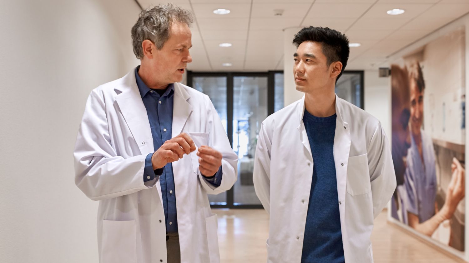 Two male doctors talking in hospital corridor