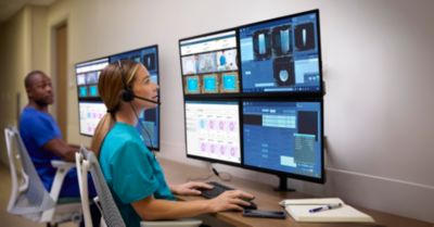 A technologist monitors multiple displays and workflows in a radiology command center