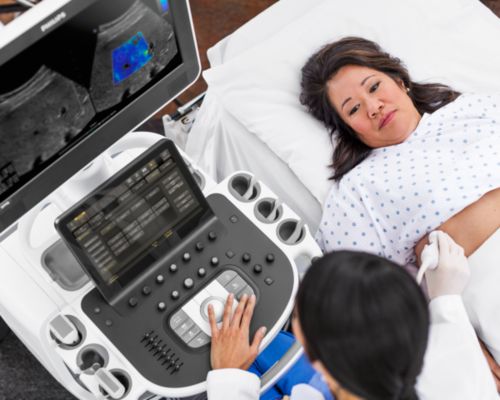 Photo of clinician performing a liver ultrasound scan of a female patient.