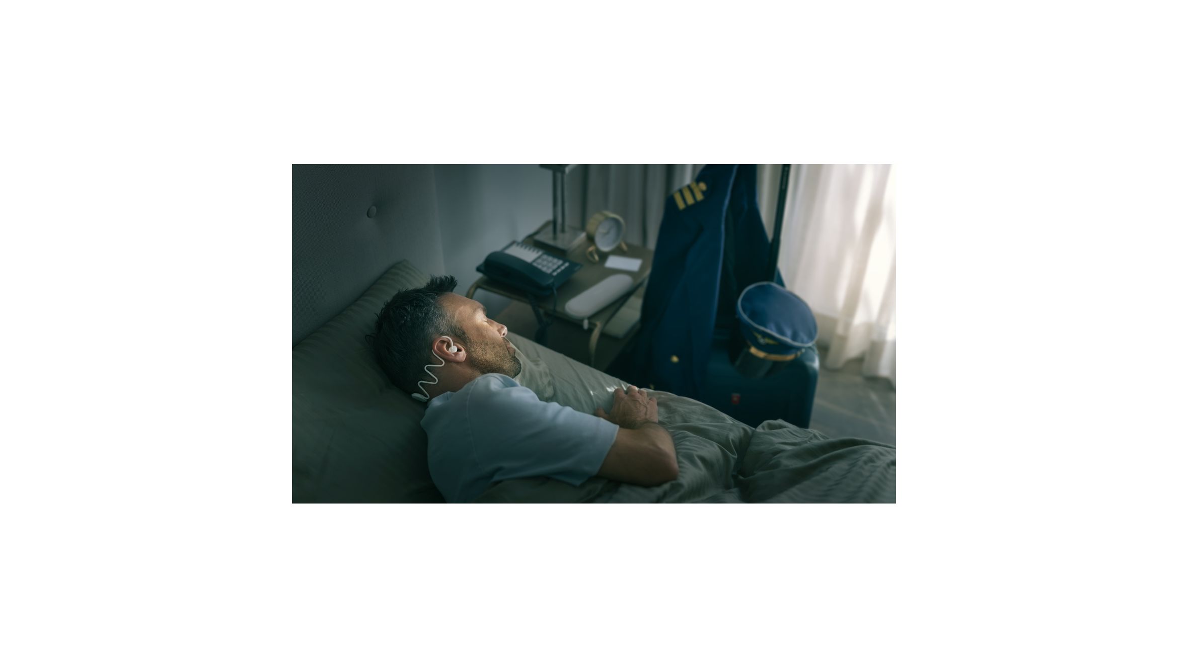 A man sleeping comfortably on his side with Philips Sleep Headphones.