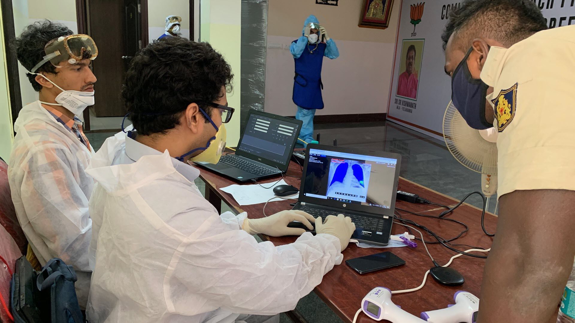 Healthcare workers using AI chest X ray analysis software for COVID 19 triage in hospital