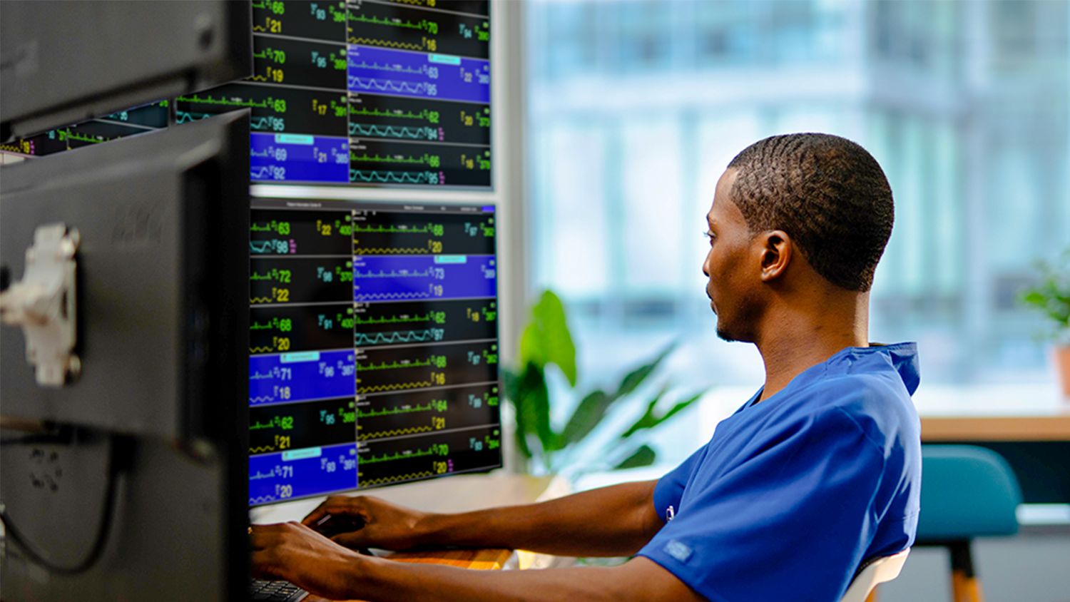 healthcare professional typing and looking at monitor