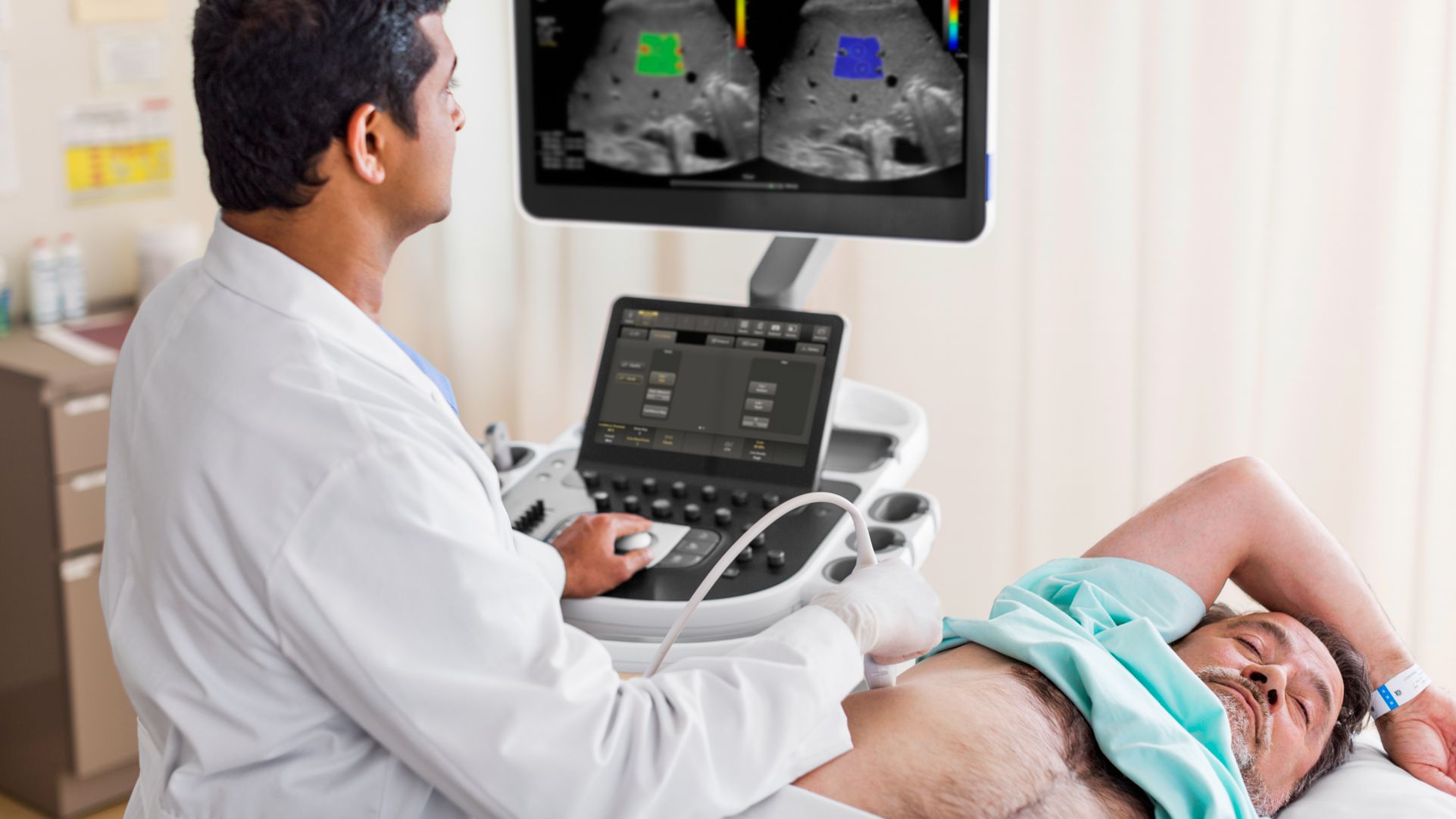 A clinician performs an abdominal ultrasound exam on a patient. 