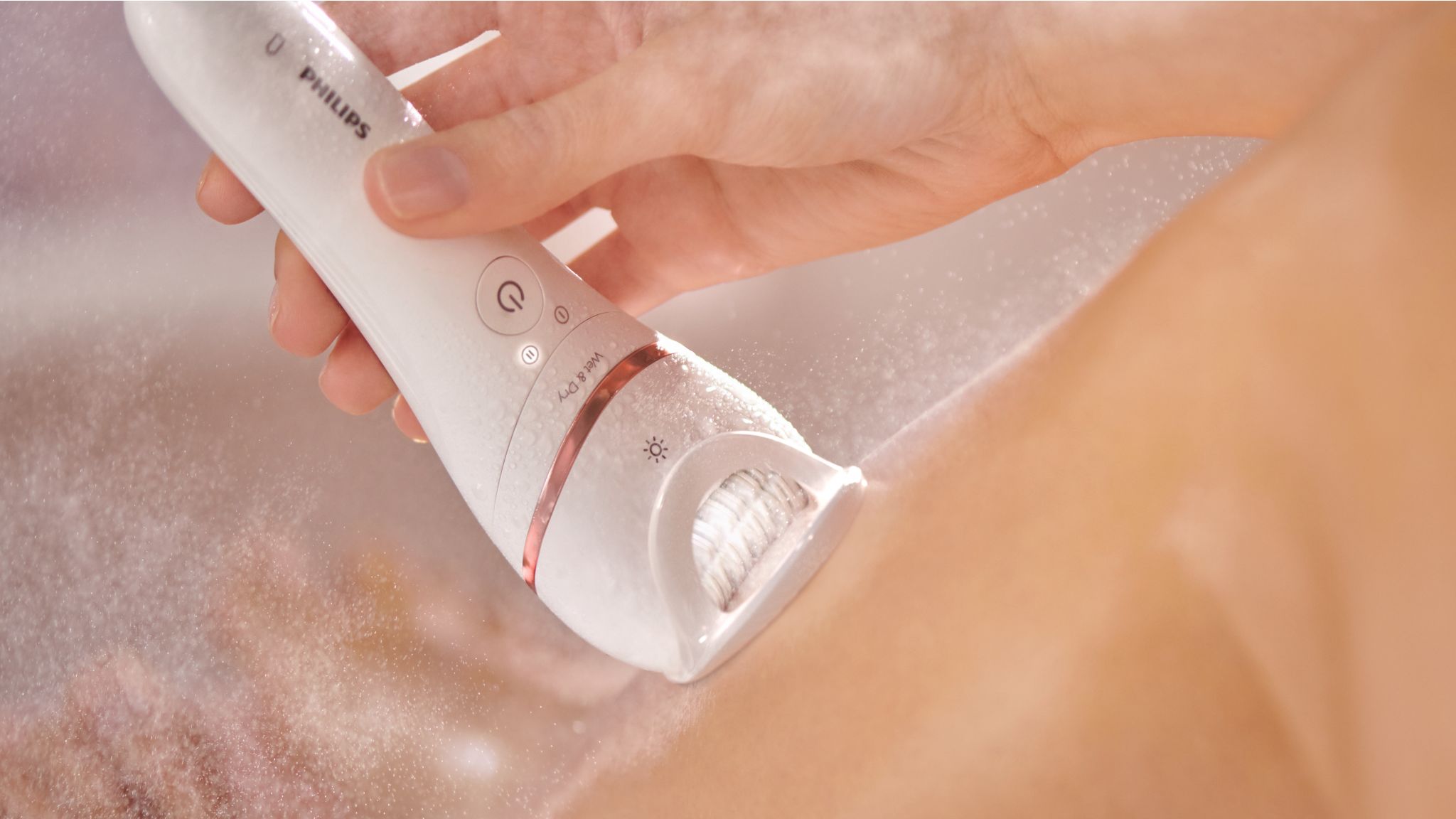 A close-up image of a Philips epilator being used to remove hair from skin.