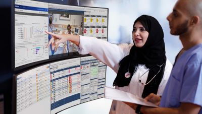 Clinicians reviewing patient data on Philips healthcare command center monitoring screens