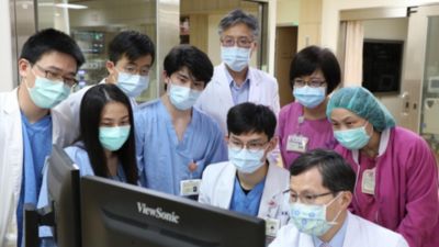 醫療團隊在顯示器上審查AI精準醫療數據