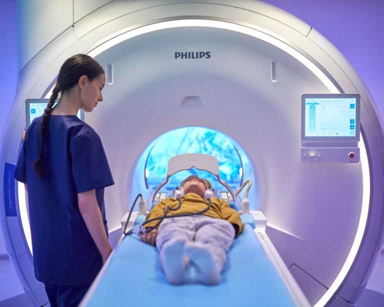 technologist comforting a patient that is undergoing an MRI scan