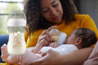 Förälder matar bebis med Philips Avent Natural-nappflaska.