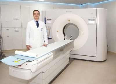 Doctor standing beside Philips CT scanner at Clínica INDISA imaging department