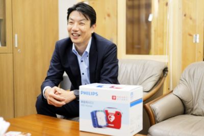 フィリップス家庭用AEDボックスを持つ石見教授