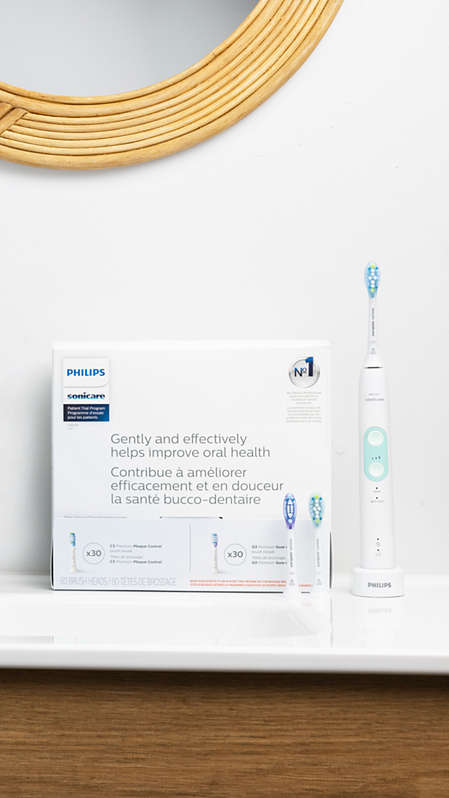 A dental professional showing a Philips Sonicare power toothbrush