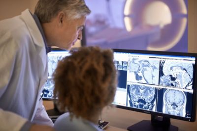 Clinicians reviewing MRI brain scans on Philips monitors in radiology suite