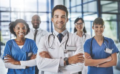Equipe de médicos e enfermeiros em pé em um corredor de hospital