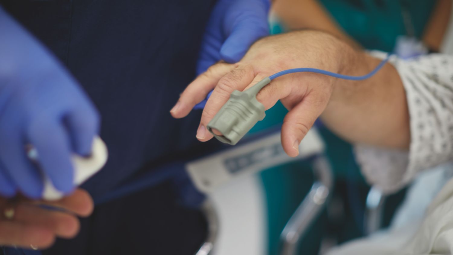 Patient ist an EKG-Leitungen, Elektroden und einer NBP-Manschette angeschlossen.