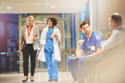 Healthcare professionals and hospital staff walking and discussing patient care in a clinical setting