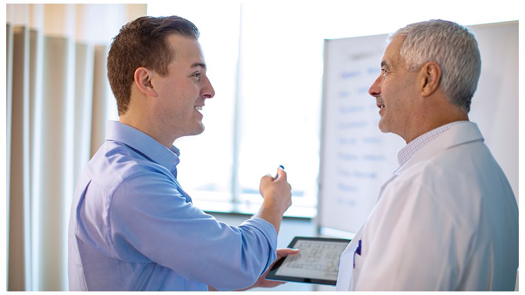 Physician and representative discussing operating room layout