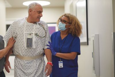 patient wearing monitor walking with nurse