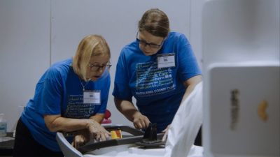 Two volunteers setting up medical equipment at community clinic