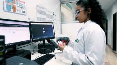 Profissional de saúde utilizando leitor de código de barras com o sistema Tasy em espaço de trabalho clínico
