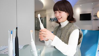 テーブルの上でソニッケアー電動歯ブラシのモデルを調べる女性