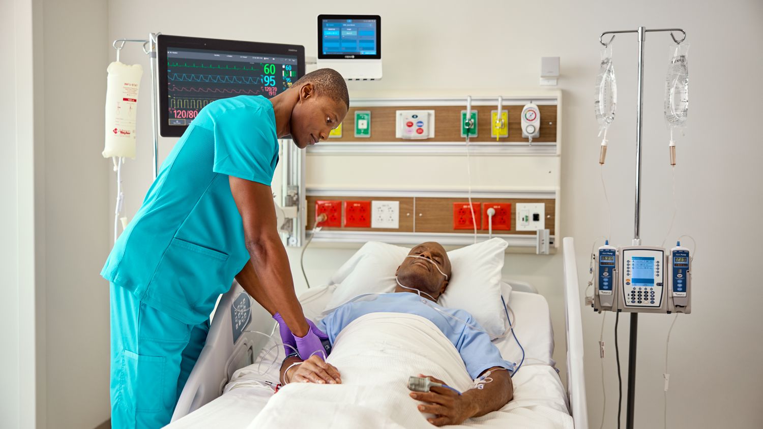 Nurse with patient and monitors in the background