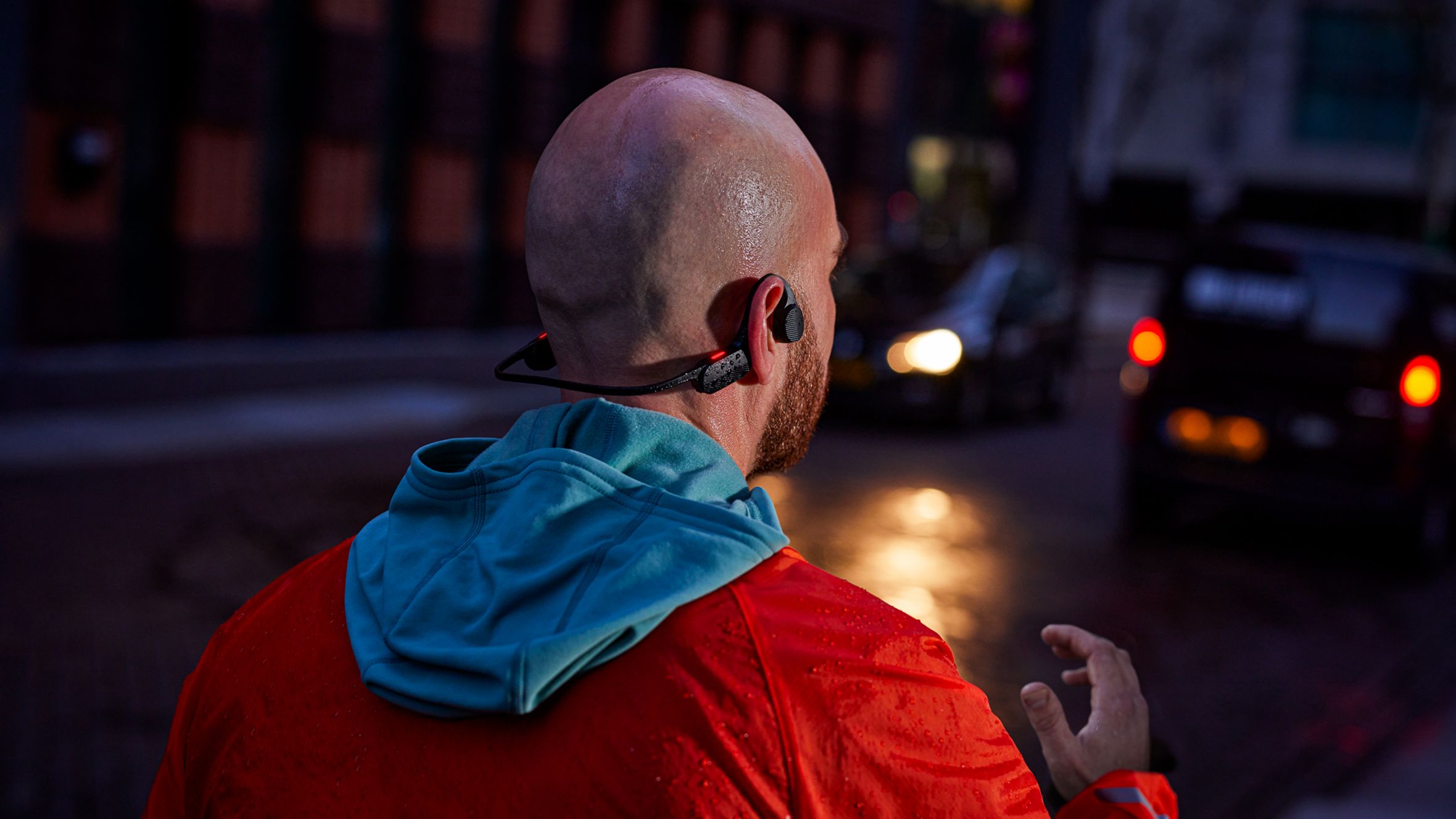 Runner wearing Philips sports headphones during an evening run, designed for performance and secure fit.